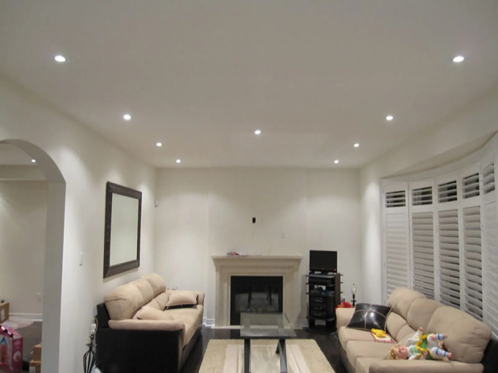 Recessed pot lights installed across a living room ceiling by Home Style Electric