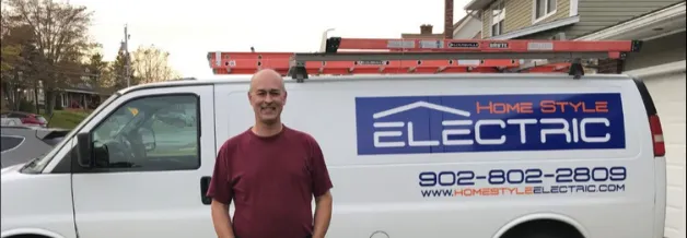 Jamie Myatt standing in front of the Home Style Electric van, ladder on the roof rack